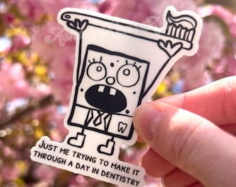 Op de afbeelding: Een witte sticker met een stripfiguur die een tandenborstel met tandpasta vasthoudt. Het personage heeft een grote open mond en een tand symbool. De tekst op de sticker luidt "JUST ME TRYING TO MAKE IT THROUGH A DAY IN DENTISTRY."
