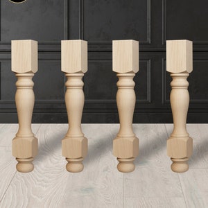 May include: Four unfinished wooden table legs with a turned design. Each leg has a hexagonal base and a rounded top.