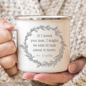 May include: White enamel mug with a black floral wreath design and the quote "If I loved you less, I might be able to talk about it more." attributed to Mr. Knightley.