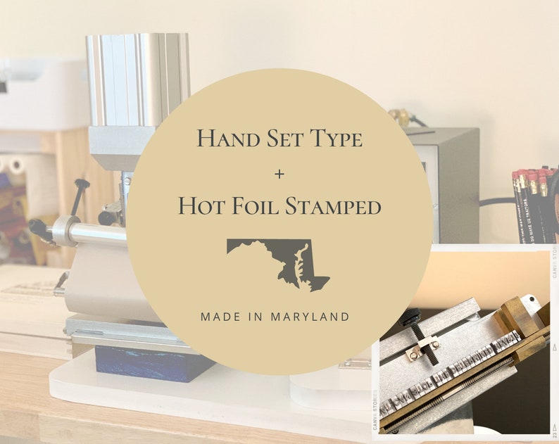 May include: A close-up of a hot foil stamping machine with a hand set type. The machine is made in Maryland and features a gold circle with the text "HAND SET TYPE + HOT FOIL STAMPED" and a black outline of the state of Maryland.