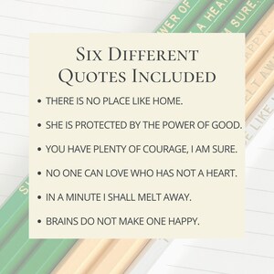 May include: A cream-colored card displays six inspirational quotes in black text. The phrases include "There is no place like home" and "She is protected by the power of good." Pencils with green and yellow text are in the background.