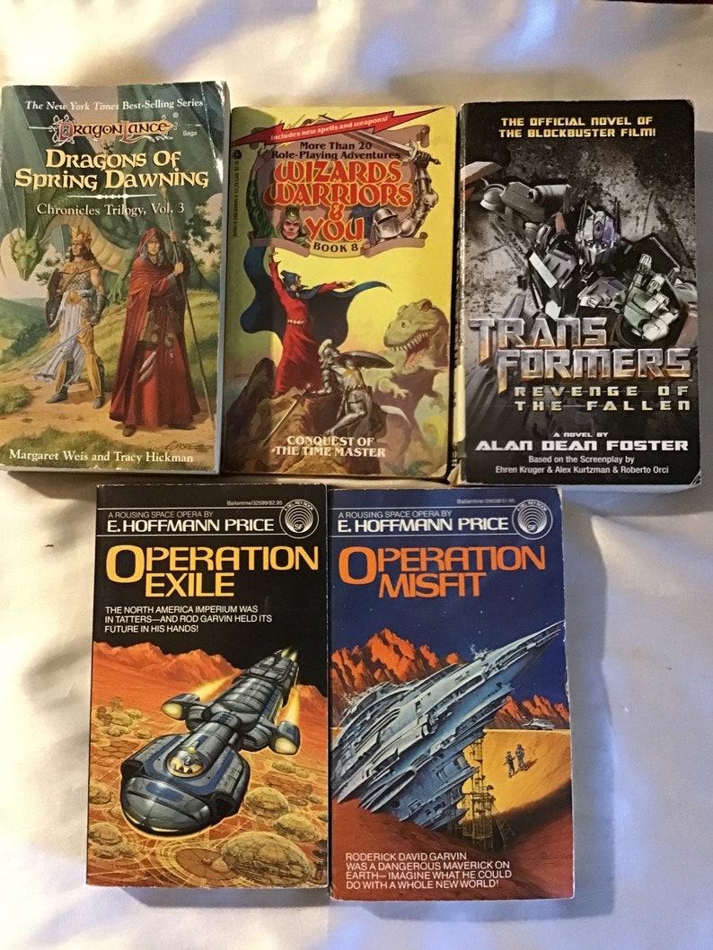 May include: A collection of nine paperback books, including fantasy novels like "Dragons of Spring Dawning" and "Wizards Warriors & You", a science fiction novel titled "Operation Exile", and a Transformers novel titled "Revenge of the Fallen".