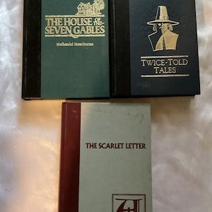 May include: Three hardcover books with gold lettering on the spines. The books are titled "The House of the Seven Gables", "Twice-Told Tales", and "The Scarlet Letter".