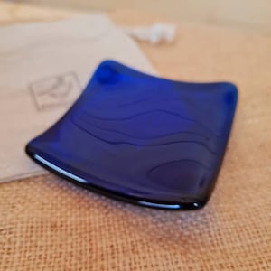 Blue glass trinket dish with lotus flower design.