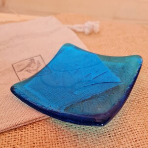 Turquoise glass trinket dish with lotus flower design.