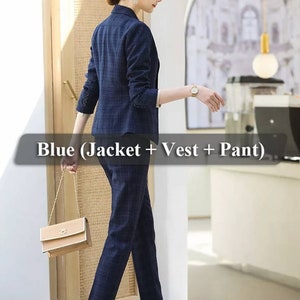 K&ouml;nnte beinhalten: Ein blauer karierter Damenanzug mit Jacke, Weste und Hose. Der Anzug wird von einem Model getragen, das eine kleine braune Handtasche h&auml;lt.