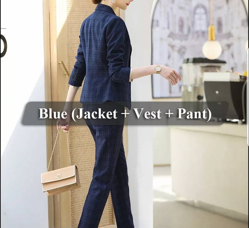 K&ouml;nnte beinhalten: Ein blauer karierter Damenanzug mit Jacke, Weste und Hose. Der Anzug wird von einem Model getragen, das eine kleine braune Handtasche h&auml;lt.