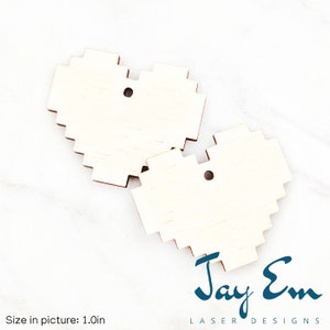 May include: Two unfinished wooden pixel heart shapes with holes for hanging. The hearts are 1 inch in size. The image includes the text "Jay Em Laser Designs".