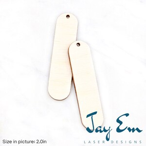May include: Two unfinished wooden tags with rounded edges and a hole at the top. The tags are approximately 2 inches long.  The tags are on a white background.  The text "Jay Em Laser Designs" is at the bottom of the image.