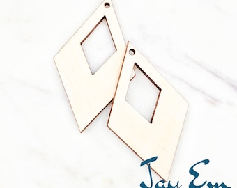 May include: Two unfinished wooden diamond-shaped earrings with a square cutout in the centre. The earrings are 2 inches in size. The earrings are made by Jay Em Laser Designs.