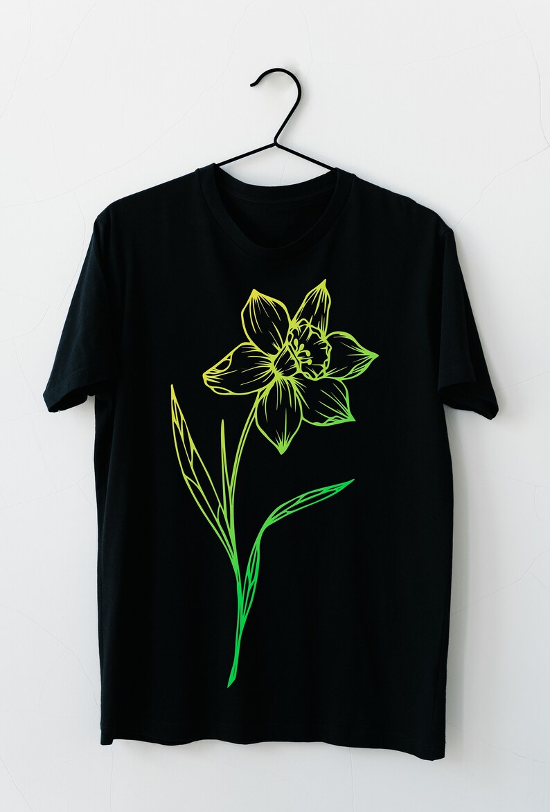 May include: A black t-shirt featuring a green and yellow outline of a daffodil flower.