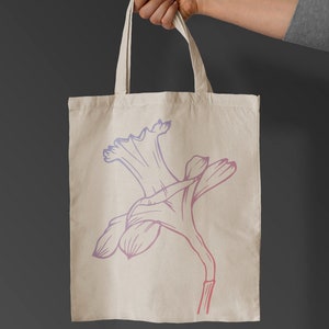 May include: A white canvas tote bag featuring a pink and purple outline of a daffodil flower.
