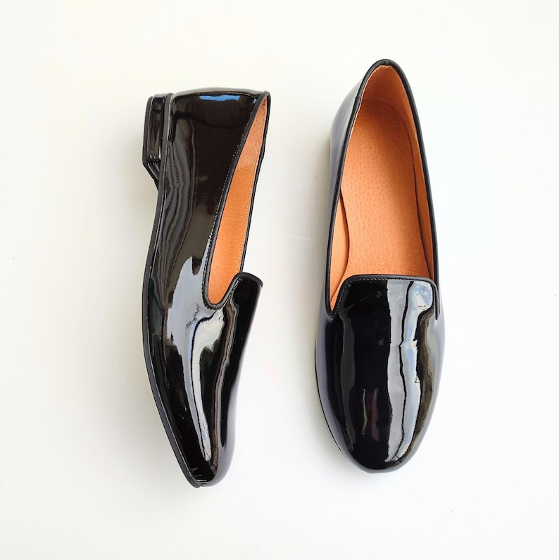 "Stylish women's black loafers in glossy leather, ideal for professional settings or casual outings, perfect for businesswomen seeking comfortable and chic footwear."
