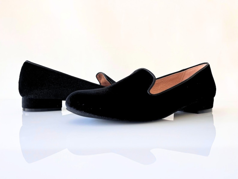 K&ouml;nnte beinhalten: Ein Paar schwarze Samt-Slipper mit niedrigem Absatz. Die Slipper sind aus weichem, pl&uuml;schigem Samt gefertigt und haben ein klassisches, elegantes Design.