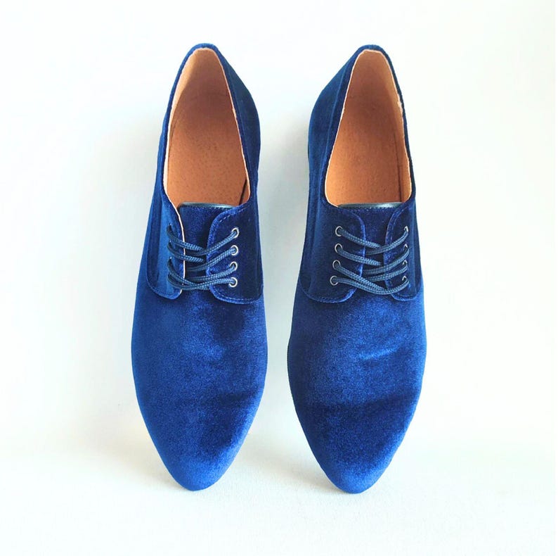 May include: A pair of blue velvet lace-up shoes with pointed toes.