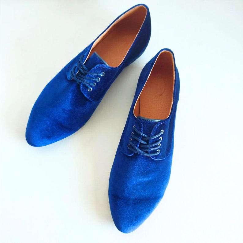 May include: A pair of blue velvet lace-up shoes with pointed toes.