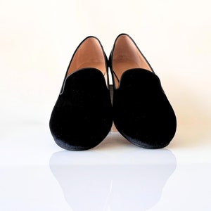 K&ouml;nnte beinhalten: Ein Paar schwarze Samt-Slipper mit spitzer Zehenpartie.