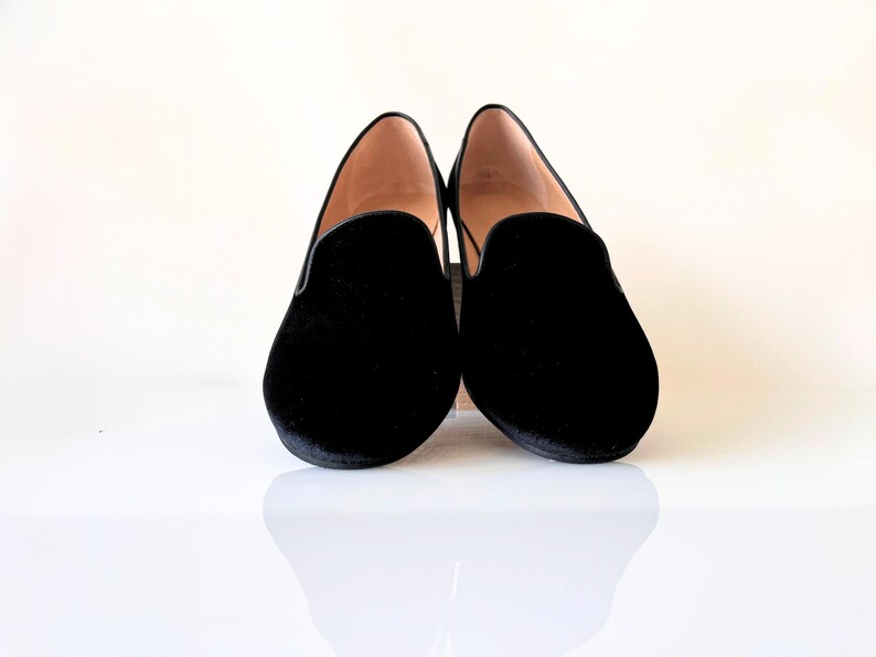 K&ouml;nnte beinhalten: Ein Paar schwarze Samt-Slipper mit spitzer Zehenpartie.