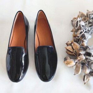 "Sleek women's slip-on loafers in glossy black leather, an all-season shoe for business settings or casual outings with friends."