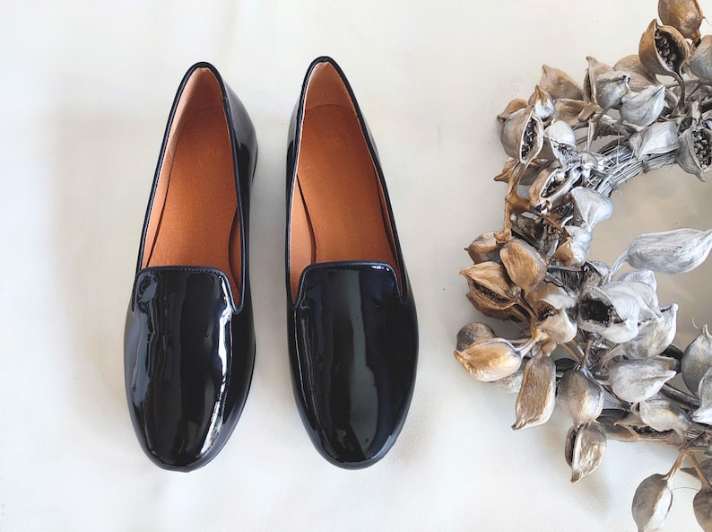 "Sleek women's slip-on loafers in glossy black leather, an all-season shoe for business settings or casual outings with friends."