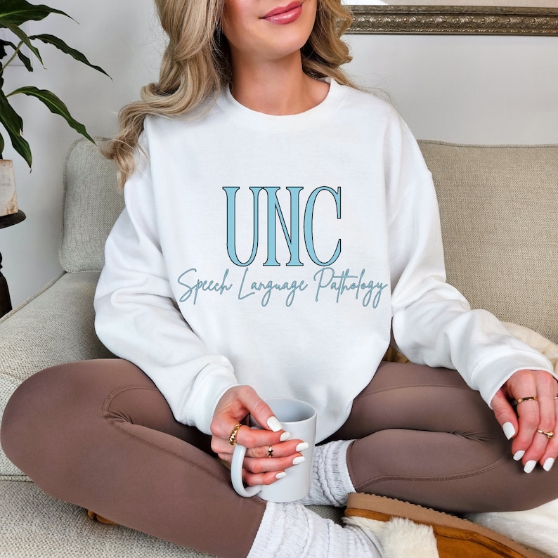 May include: White sweatshirt with the text "UNC Speech Language Pathology" in blue lettering.