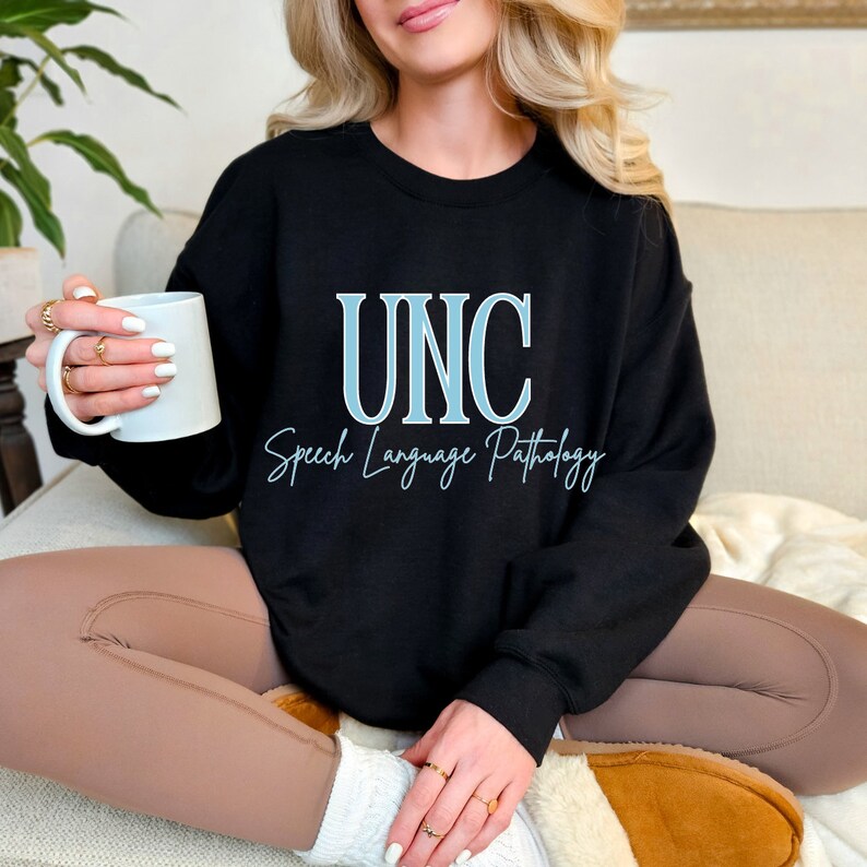 May include: Black sweatshirt with the text "UNC Speech Language Pathology" in blue lettering.