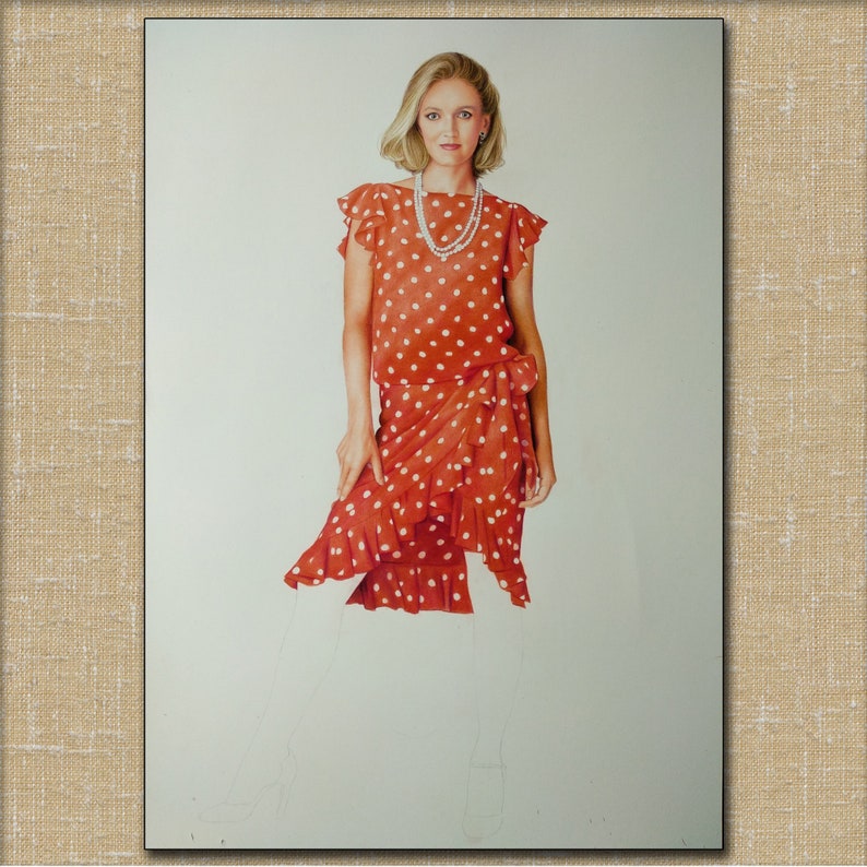 Op de afbeelding: Een vrouw in een rode polkadotjurk met een witte ruche. Ze draagt een parelketting en heeft blond haar.