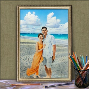 Puede incluir: Una pintura de una pareja en una playa. El hombre lleva una camisa blanca y azul con estampado y la mujer lleva un vestido naranja brillante. La pintura est&aacute; enmarcada en oro.