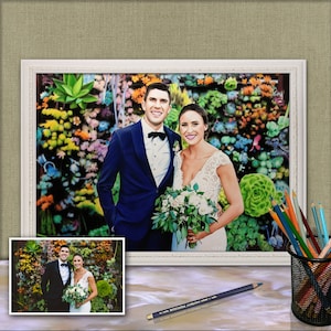 Puede incluir: Una pintura enmarcada de una pareja de bodas de pie frente a una pared de suculentas coloridas. El novio lleva un traje azul y una corbata de mo&ntilde;o negra. La novia lleva un vestido blanco y sostiene un ramo de flores blancas.