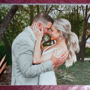 Puede incluir: Una pareja en un entorno de bosque, el hombre con un traje gris y la mujer con un vestido blanco, se miran con sonrisas en sus rostros.