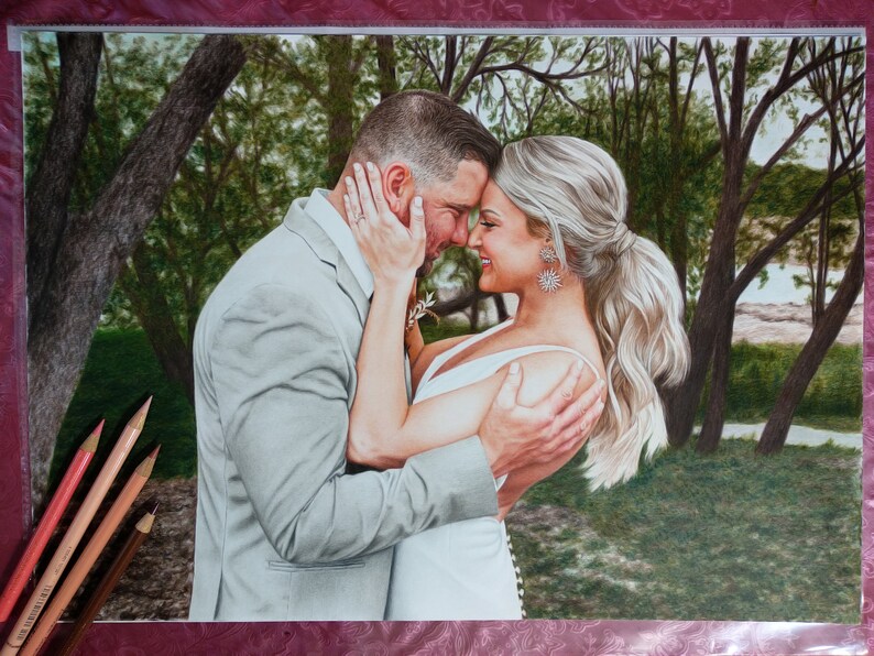 Puede incluir: Una pareja en un entorno de bosque, el hombre con un traje gris y la mujer con un vestido blanco, se miran con sonrisas en sus rostros.
