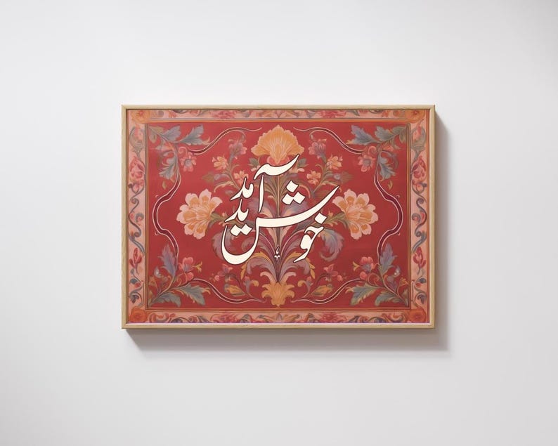 May include: A framed artwork featuring a red background with floral patterns in shades of orange, pink, and green. The artwork has white calligraphy in the center. The frame is a light brown color.