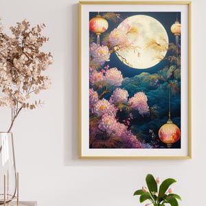 May include: A framed art print featuring a full moon, pink flowers, and hanging lanterns. The artwork has a gold frame and a dark blue background. The flowers are in full bloom, and the lanterns are lit with a warm glow.
