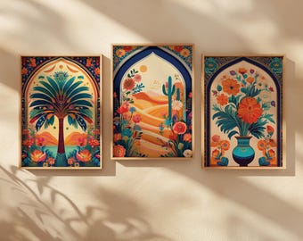 May include: Three framed art prints with a desert theme. Each print features a colorful illustration within an arched frame. One shows a palm tree, another a cactus, and the third a vase of flowers. The artwork has a warm color palette.