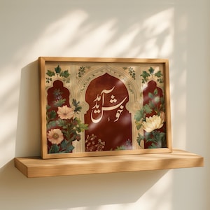 May include: A framed art print featuring an ornate arch design with floral accents and calligraphy in white. The artwork has a rich, reddish-brown background and is set within a wooden frame, resting on a wooden shelf.