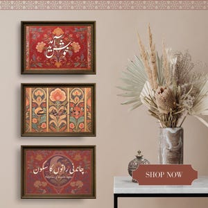 May include: Three framed art prints with ornate floral designs and calligraphy in a warm color palette. The top print has a red background, the middle one has a multi-colored design, and the bottom one has a red background. A vase of dried flowers sits to the right.