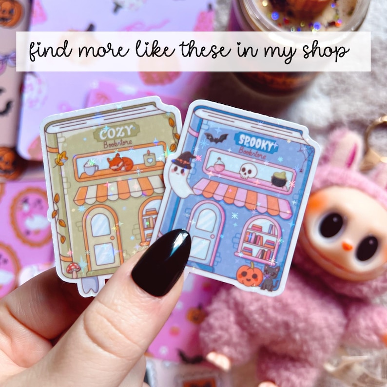 Puede incluir: Dos pegatinas con forma de edificios, una con la etiqueta "Cozy Bookstore" y la otra "Spooky Bookstore". La pegatina acogedora es de color beige y naranja, mientras que la espeluznante es azul y naranja. El texto "find more like these in my shop" est&aacute; en la parte superior.