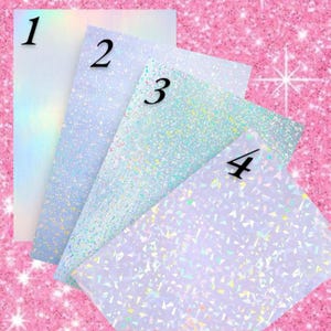 Puede incluir: Cuatro hojas de papel hologr&aacute;ficas iridiscentes con los n&uacute;meros 1, 2, 3 y 4 impresos en ellas. Las hojas tienen diferentes patrones de purpurina y escamas hologr&aacute;ficas.