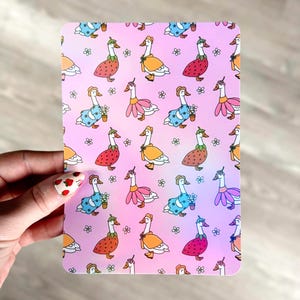 Puede incluir: Un fondo rosa con un patrón repetido de gansos blancos que llevan diferentes atuendos. Los gansos llevan trajes de fresa, flor y capa. Hay pequeñas flores blancas dispersas por todo el fondo.