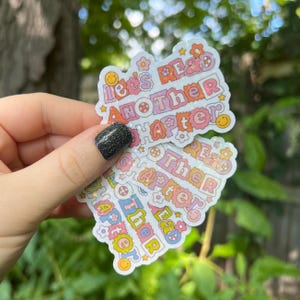 May include: A stack of colorful stickers with the text "Let's Read Another Chapter" on the top sticker. The stickers are decorated with flowers and smiley faces.