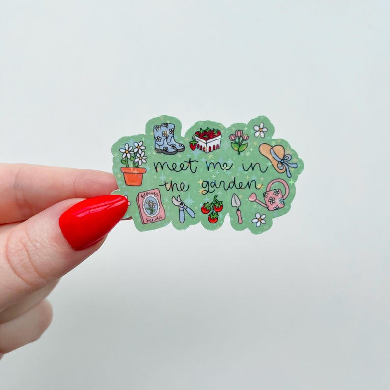 Peut inclure: Un autocollant vert avec le texte "meet me in the garden" et des illustrations sur le th&egrave;me du jardin. L'autocollant pr&eacute;sente des images d'un pot de fleurs, de bottes, de fraises, de fleurs, d'un chapeau, d'un arrosoir, d'un paquet de graines, de cisailles, de tomates et d'une truelle.