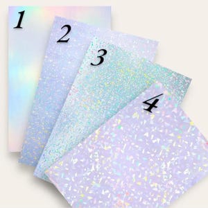 May include: Four sheets of iridescent paper in shades of blue, purple, and white, numbered 1 through 4 in black. The papers have a shimmering, glittery effect, with varying patterns and textures. The overall effect is a dreamy, ethereal aesthetic.