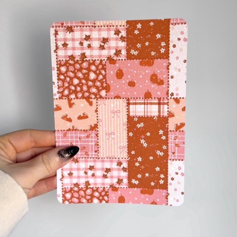 May include: A rectangular sticker sheet featuring a patchwork design of various autumn-themed patterns in shades of orange, pink, and white. The grid includes motifs of pumpkins, fall leaves, plaid, leopard print, small flowers, and bows.