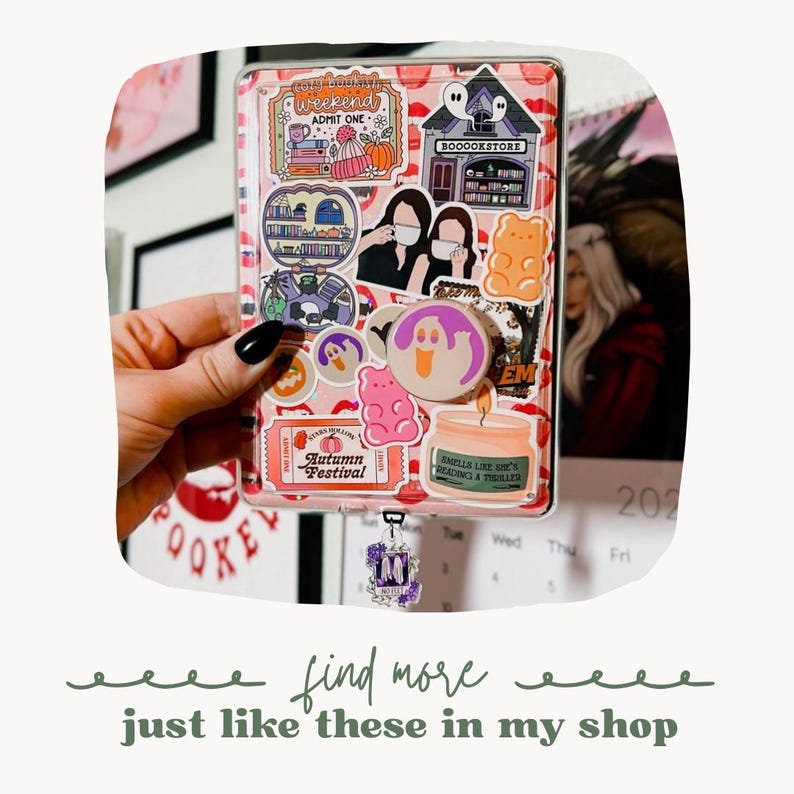 May include: A pink and clear plastic planner with a variety of colorful stickers, including a ghost, a gummy bear, and a book store. The planner has a charm attached to it with the letter "M" on it.