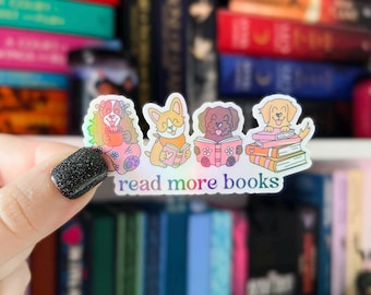 May include: A holographic sticker with four cartoon dogs reading books. The sticker says "read more books".