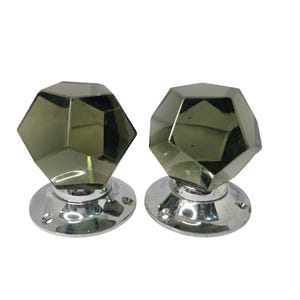 Könnte beinhalten: Ein Paar antike Türknauf mit facettiertem Glas in dunkelgrüner Farbe. Die Knäufe sind auf einer silbernen Basis montiert.