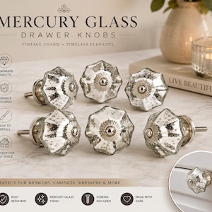 May include: A set of six mercury glass drawer knobs with a faceted, star-shaped design and a metallic silver finish. Each knob features a central silver-toned metal cap and a threaded screw attachment for installation on cabinets or furniture.