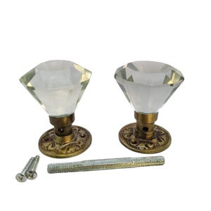 Può includere: Due pomelli per porte in vetro trasparente a forma di diamante con basi in ottone ornate e due viti.