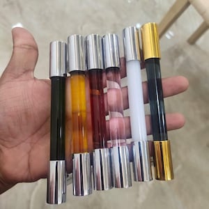 May include: Six glass roller bottles with silver caps. The bottles are filled with different colored liquids: green, yellow, red, clear, white, and black.