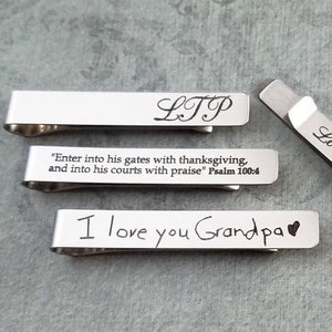 May include: Four silver tie clips with different engraved messages. The messages are "LTP", "Enter into his gates with thanksgiving, and into his courts with praise" Psalm 100:4, "I love you Grandpa", and "Love, Celeste".